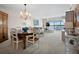 Open-concept living room and dining area with chandelier, comfortable seating, and water views at 4420 Exeter Dr # 303, Longboat Key, FL 34228