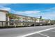 Exterior view of covered parking area with mature palm trees lining the condominium complex at 4420 Exeter Dr # 303, Longboat Key, FL 34228