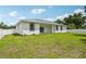 Backyard view showing the lawn and the back of the house under a sunny, blue sky at 4855 Dragon St, North Port, FL 34288