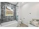 Modern bathroom features a tub, shower with gray marble-style surround, and a granite vanity top at 4855 Dragon St, North Port, FL 34288