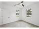 Bright bedroom with a ceiling fan, two windows providing natural light, and wood-look tile flooring at 4855 Dragon St, North Port, FL 34288