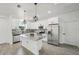 Modern kitchen featuring white cabinets, gray backsplash, an island, stainless steel appliances, and tile floors at 4855 Dragon St, North Port, FL 34288