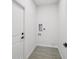 Small laundry room with gray wood-look tile flooring and hookups for the washer and dryer at 4855 Dragon St, North Port, FL 34288