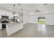 Open-concept living space featuring an island kitchen, gray wood-look tile, and sliding glass doors at 4855 Dragon St, North Port, FL 34288