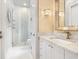 An elegant bathroom featuring a glass-enclosed shower and a marble vanity with decorative lighting at 4907 Topsail Dr, Nokomis, FL 34275