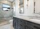 A modern bathroom with a glass-enclosed shower, dual sinks, marble countertop and luxury finishes at 4907 Topsail Dr, Nokomis, FL 34275