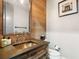 A rustic bathroom features wood accents, a copper sink, and modern fixtures under warm lighting at 4907 Topsail Dr, Nokomis, FL 34275