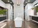 Modern bathroom with a standalone tub, dual showers, and marble accents at 4907 Topsail Dr, Nokomis, FL 34275