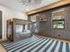 A stylish bedroom featuring a bunk bed, wood beam, and a gray accent wall with two windows at 4907 Topsail Dr, Nokomis, FL 34275