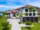 Beautiful two-story home with a terracotta tile roof and manicured front yard with palm trees at 4907 Topsail Dr, Nokomis, FL 34275