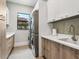 This modern laundry room features sleek cabinetry, counter space, and stacked washer and dryer units at 4907 Topsail Dr, Nokomis, FL 34275
