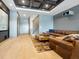 Modern living room featuring a large comfortable leather couch, movie projector, and custom ceiling at 4907 Topsail Dr, Nokomis, FL 34275