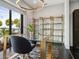 Bright office space with a modern glass desk, gold accents, and views of the water at 4907 Topsail Dr, Nokomis, FL 34275