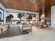Open-air entertaining space with outdoor kitchen, dining area, and comfortable seating overlooking the water at 4907 Topsail Dr, Nokomis, FL 34275