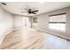 Spacious bedroom with light hardwood floors, ceiling fan, and two windows with woven shades at 4913 32Nd E St, Bradenton, FL 34203