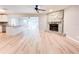 Open-concept living room with hardwood floors, stone fireplace, and access to kitchen and patio at 4913 32Nd E St, Bradenton, FL 34203
