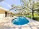 Backyard pool enclosed by a screen, surrounded by lush greenery and patio space at 4913 32Nd E St, Bradenton, FL 34203