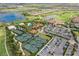 Aerial view of a community featuring a pool, clubhouse, tennis courts, lakes and manicured landscaping at 5234 Napoli Run, Bradenton, FL 34211