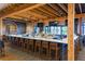 Modern bar area with a long countertop, bar stools, track lighting, and multiple TV screens at 5234 Napoli Run, Bradenton, FL 34211