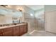 Elegant bathroom featuring dual vanities, a frameless glass shower, and neutral tiling at 5234 Napoli Run, Bradenton, FL 34211