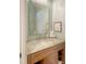Elegant half-bath with a granite countertop vanity, decorative mirror, and soft turquoise walls creating a stylish powder room at 5234 Napoli Run, Bradenton, FL 34211