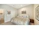 Cozy bedroom featuring neutral walls, a plush bed with patterned bedding, and decorative wall art, creating a relaxing atmosphere at 5234 Napoli Run, Bradenton, FL 34211
