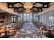 Well-lit dining room featuring modern chandeliers, multiple tables, and large windows offering a scenic view at 5234 Napoli Run, Bradenton, FL 34211