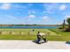 Scenic golf course view with a golf cart, lake, and lush green landscape, perfect for a day on the greens at 5234 Napoli Run, Bradenton, FL 34211