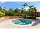 Outdoor spa featuring brick walls and tile stairs, surrounded by beautiful shrubs and vibrant green foliage at 5234 Napoli Run, Bradenton, FL 34211