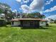 Rear view of house with large yard and screened in lanai at 5629 Boulder Blvd, Sarasota, FL 34233