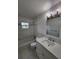 Modern bathroom with marble tile, updated vanity with sink, mirror, and new light fixtures at 5629 Boulder Blvd, Sarasota, FL 34233