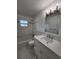 Modern bathroom with marble tile, updated vanity with sink, mirror, and new light fixtures at 5629 Boulder Blvd, Sarasota, FL 34233