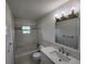 Modern bathroom with marble tile, updated vanity with sink, mirror, and new light fixtures at 5629 Boulder Blvd, Sarasota, FL 34233