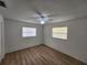 Bright bedroom featuring wood floors, a ceiling fan, and two windows offering natural light at 5629 Boulder Blvd, Sarasota, FL 34233