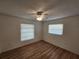 Bright bedroom featuring wood floors, a ceiling fan, and two windows offering natural light at 5629 Boulder Blvd, Sarasota, FL 34233