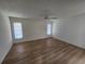 Bright bedroom featuring wood floors, a ceiling fan, and two windows offering natural light at 5629 Boulder Blvd, Sarasota, FL 34233