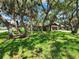 Landscaped front yard with mature trees around a single-story house with a two-car garage at 5629 Boulder Blvd, Sarasota, FL 34233
