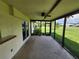 Screened lanai with a ceiling fan overlooking a large grassy yard at 5629 Boulder Blvd, Sarasota, FL 34233