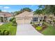 Inviting single-Gathering home featuring a tile roof, two-car garage, and meticulously landscaped front yard with mature trees at 6155 Aviary Ct, Bradenton, FL 34203