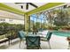 Outdoor patio with a table and chairs overlooks the pool and a green garden area at 6155 Aviary Ct, Bradenton, FL 34203