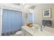 Bright bathroom with a blue-striped shower curtain and blue artwork at 6216 Donnington Ct, Sarasota, FL 34238