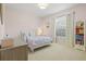 Bright bedroom featuring a light-colored wall, window and carpet with modern furnishings and decor at 6216 Donnington Ct, Sarasota, FL 34238