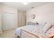 Bedroom with double door closet, round mirror on wall, a floral bed set and gray dresser at 6216 Donnington Ct, Sarasota, FL 34238