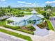 Community clubhouse with a courtyard, lush landscaping, and views of the surrounding neighborhood and pond at 6216 Donnington Ct, Sarasota, FL 34238