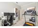 Dual-use room with a treadmill, a desk and a bookcase full of books at 6216 Donnington Ct, Sarasota, FL 34238
