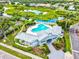Aerial view of a charming light blue home with a pool, beautiful landscaping, and a scenic lake view at 6216 Donnington Ct, Sarasota, FL 34238