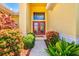 Inviting front entrance with a beautiful red door and lush, colorful landscaping at 6216 Donnington Ct, Sarasota, FL 34238