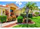 Lovely home with manicured landscaping, bright flowers, and a charming red front door at 6216 Donnington Ct, Sarasota, FL 34238