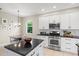 Modern kitchen features stainless steel appliances, white cabinets, and an island with a black countertop at 6216 Donnington Ct, Sarasota, FL 34238