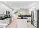 Bright kitchen with white cabinets, black countertops, stainless steel appliances, and an island at 6216 Donnington Ct, Sarasota, FL 34238